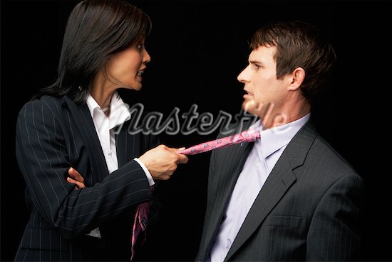 Девушка тянет мужчину за галстук